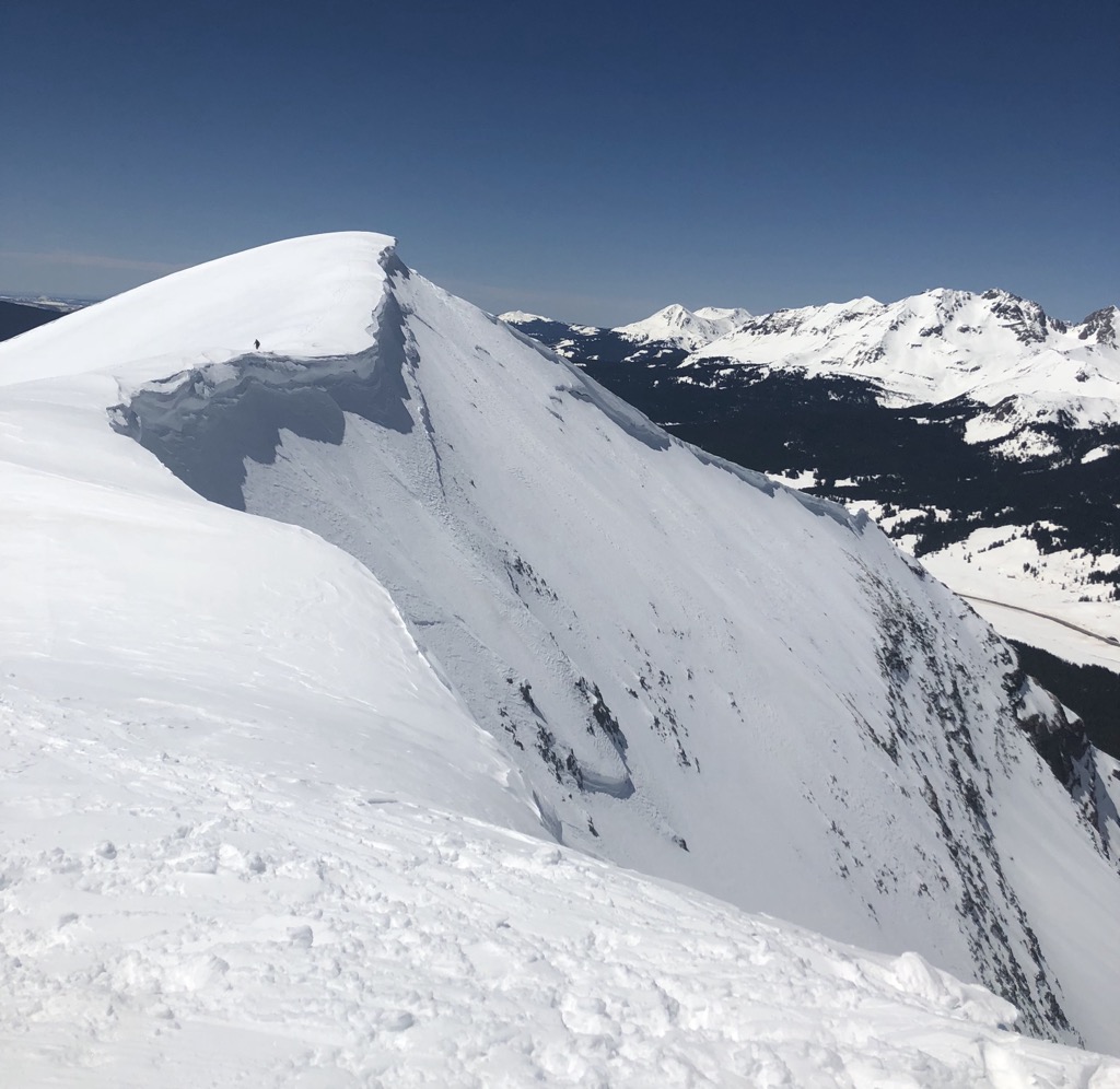 The distant skier is me, giving a few meters of berth from the edge of the cornice. 	Photo: Sergei Poljak. Avalanche Safety