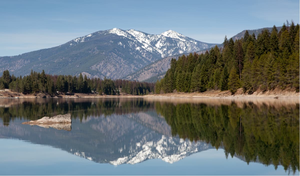 Cabinet Mountains reflecting in the calm waters of Trout Creek