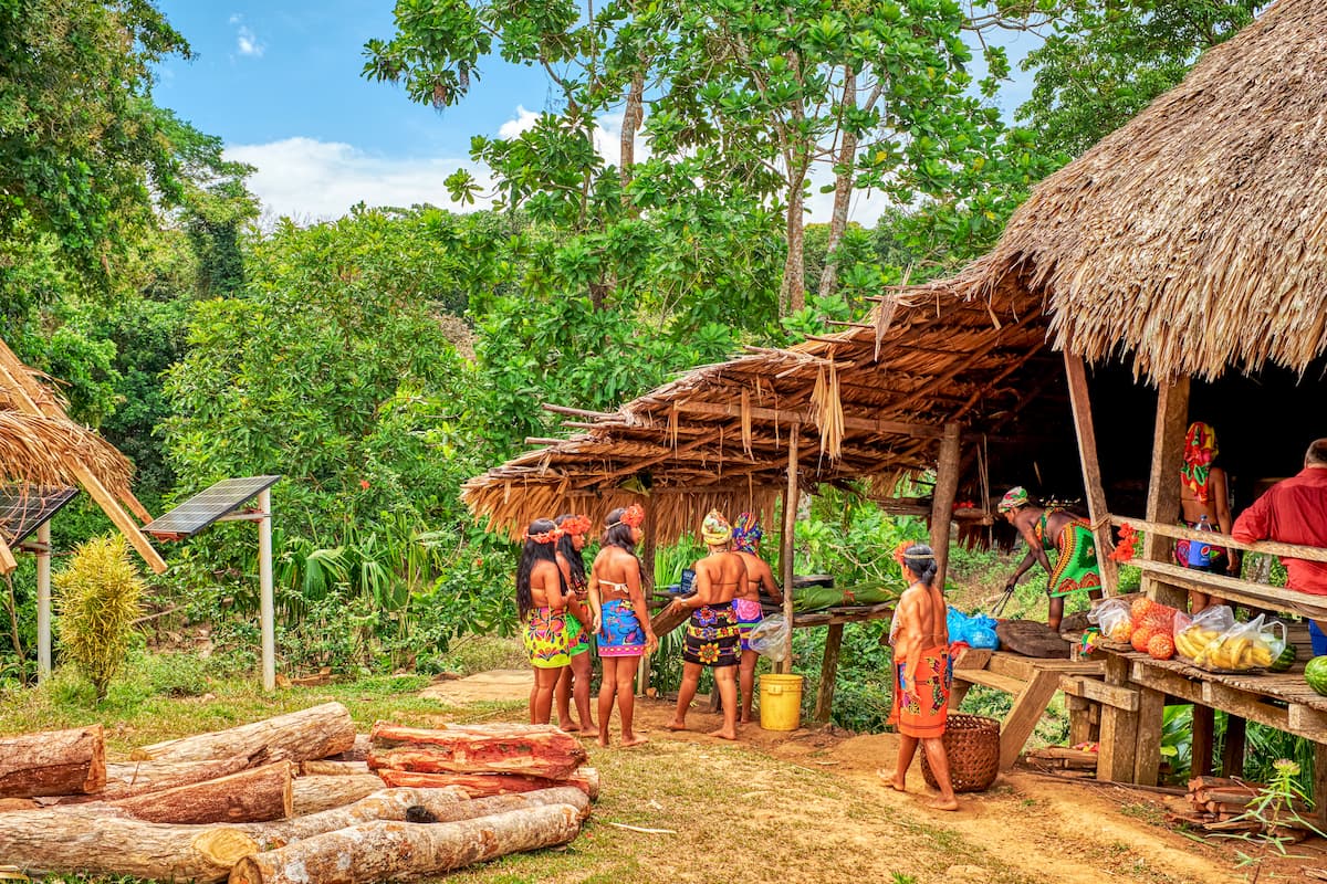 Native Embera women preparing food to visiting tourists and dressed in native garments. Costa Rica-Panama Ranges