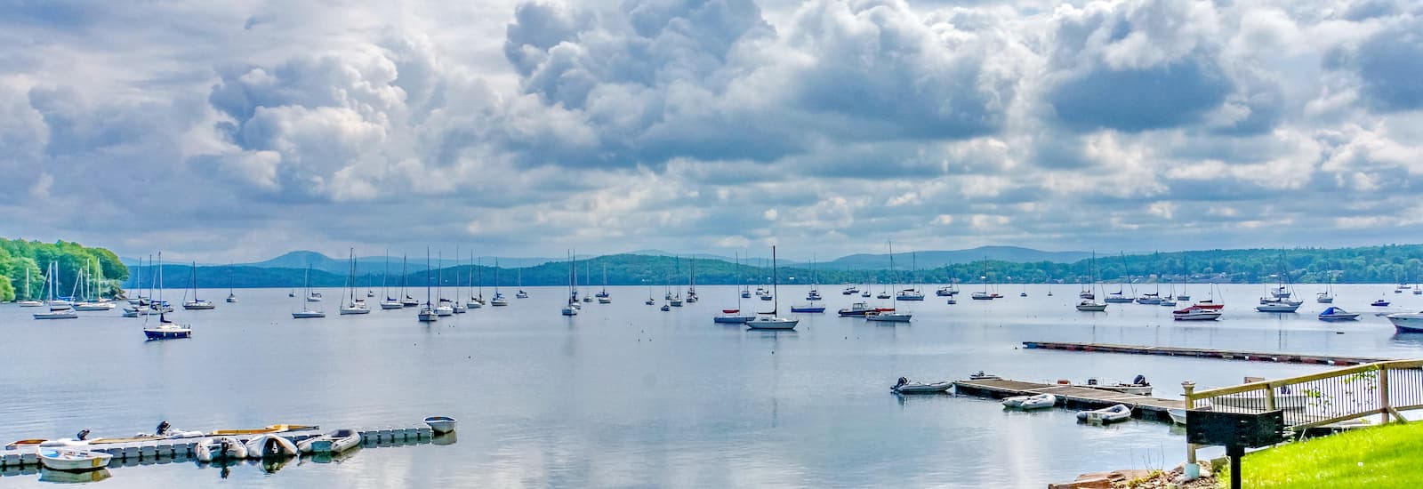 Lake Champlain, with many sailboats moored with the Green Mountains of Vermont across the lake