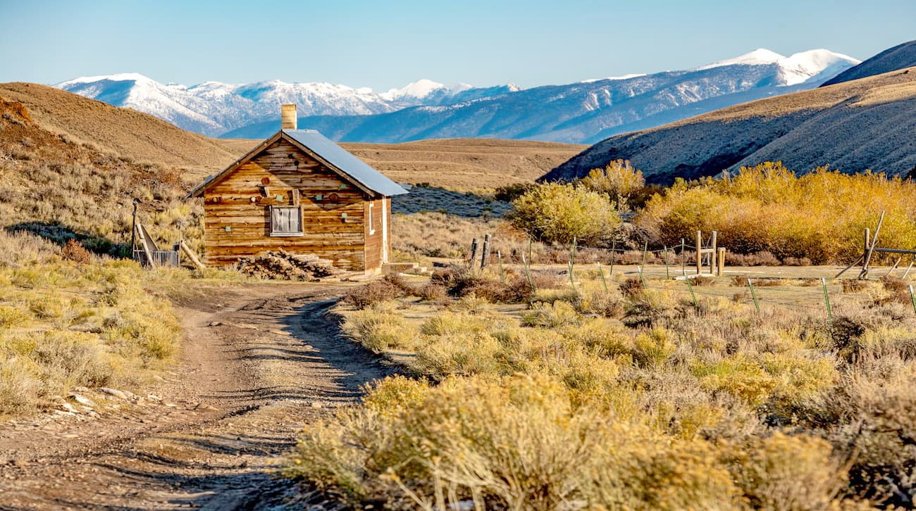Dirt road leads to a remote cabin in the fall time of the year