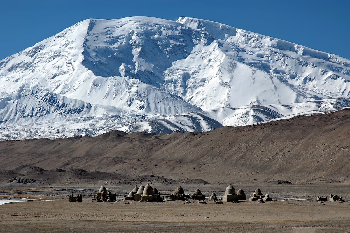 Old Kyrgyz cemetery on the background of Muztagh Ata mountain