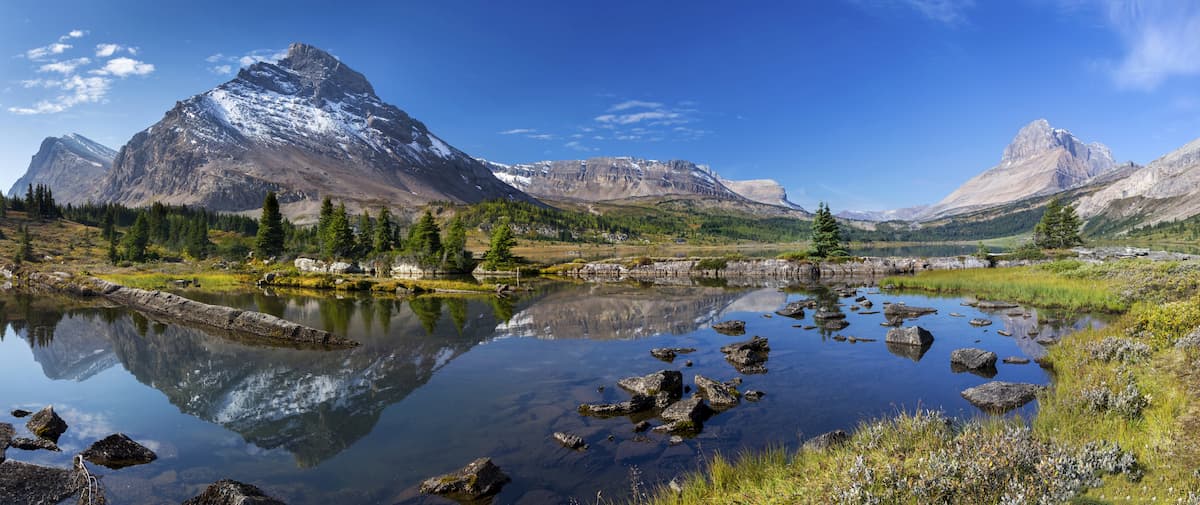 Wide Panoramic Landscape Scenic View of Baker Lake and Distant Canadian Rocky Mountain Peaks near Lake Louise in Banff National Park