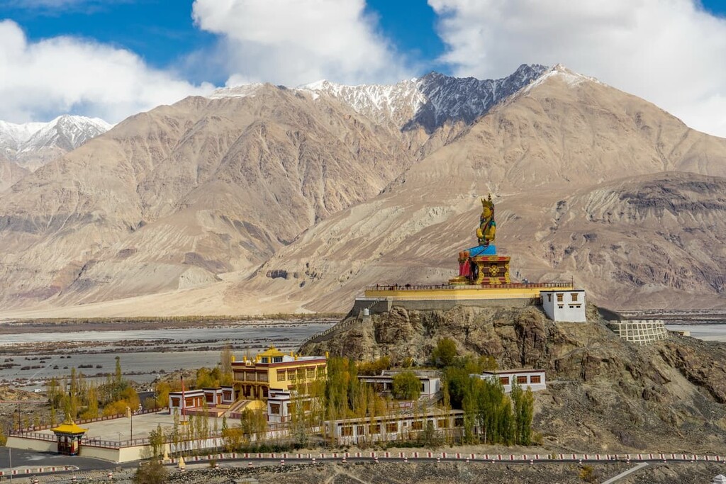 Maitreya Buddha statue with Himalaya mountains in the background from Diskit Monastery or Diskit Gompa, Nubra valley, Leh Ladakh