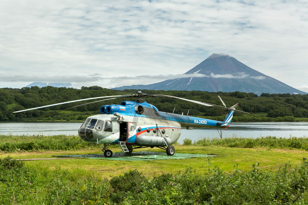 Helicopter on background Kurile lake and Ilyinsky volcano