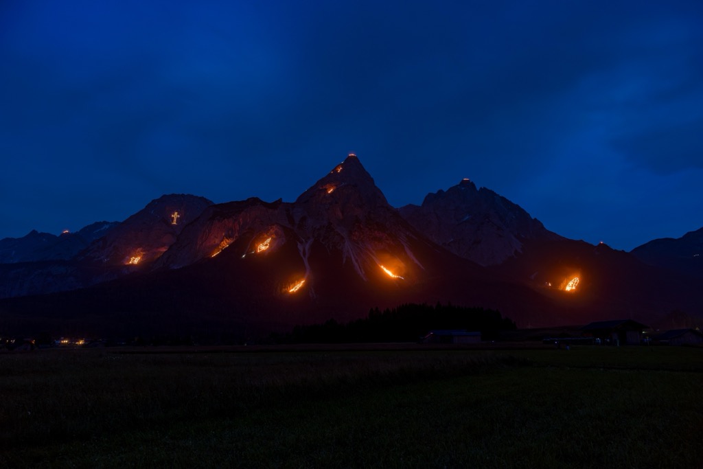 Summer solstice fires illuminate the slopes of Tyrol’s mountains, as seen here within the Tiroler Zugspitz Arena ski area. Brandenberg Alps