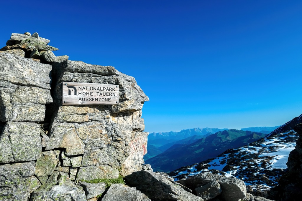 A wooden signpost for High Tauern National Park on a rock high in the Central Alps. Carinthia