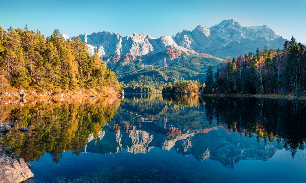Der Eibsee im Herbst mit goldenen Lärchen am Ufer und der Zugspitze dahinter, Bayern