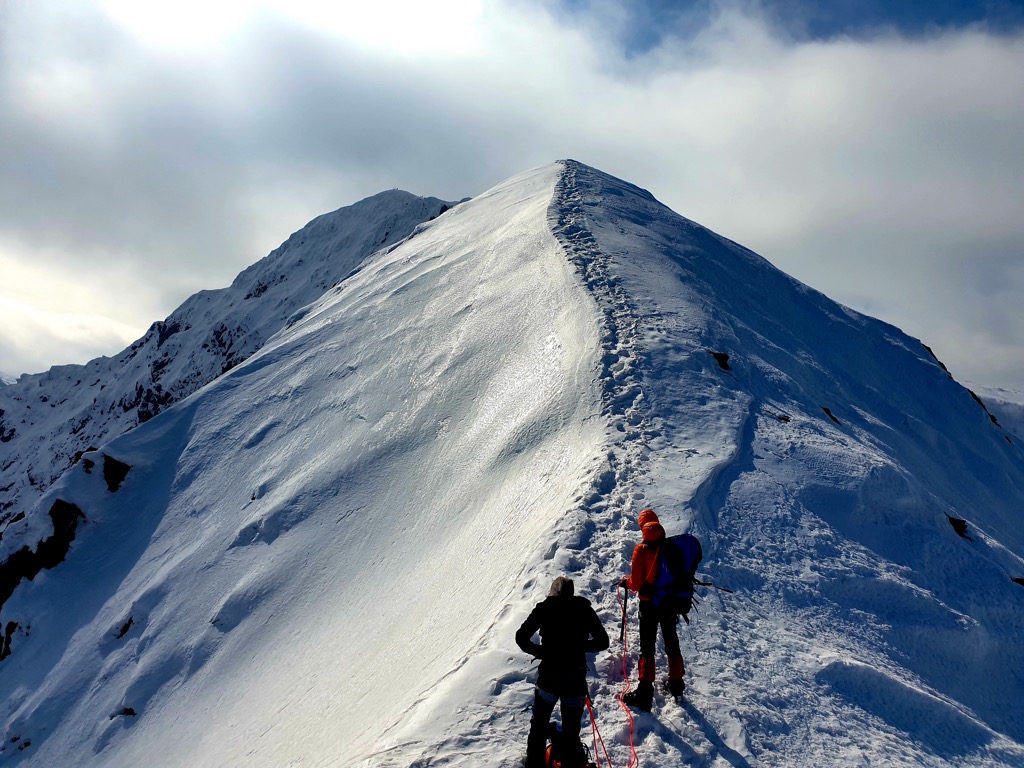 Climbing the ridgeline of Serbota Peak in winter. Fagaras Mountains