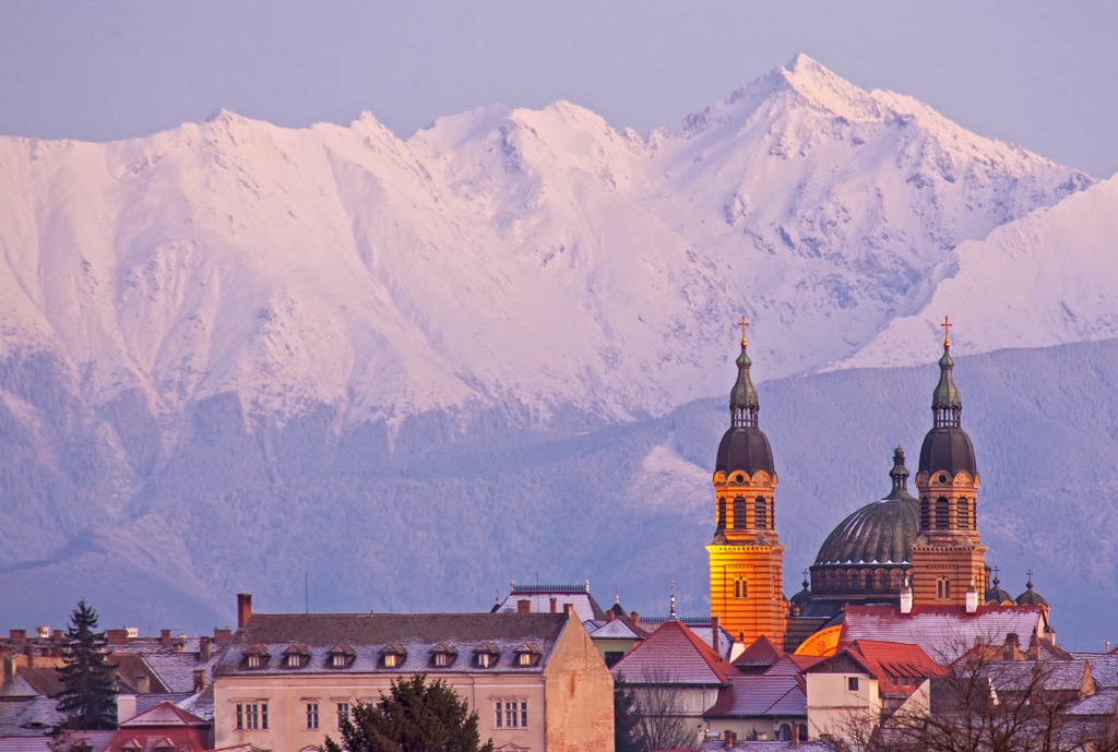 The city of Sibiu in winter, with the snow-covered Făgăraș towering behind. Fagaras Mountains