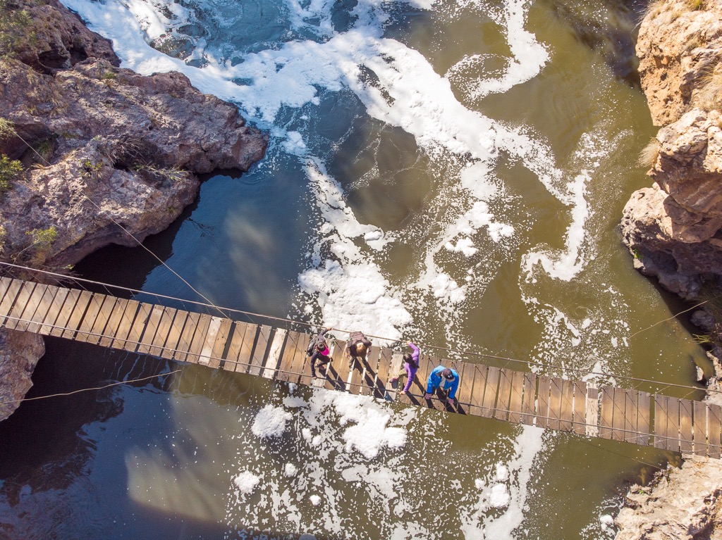 Hikers crossing the suspension bridge over the Hennops River. Magaliesberg