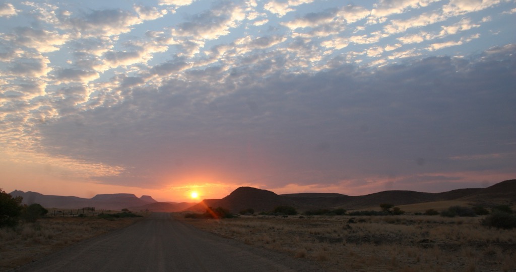 The sun setting over an open road in Namibia. Photo: Sergei Poljak. Nomad-Friendly Countries for Mountain Lovers