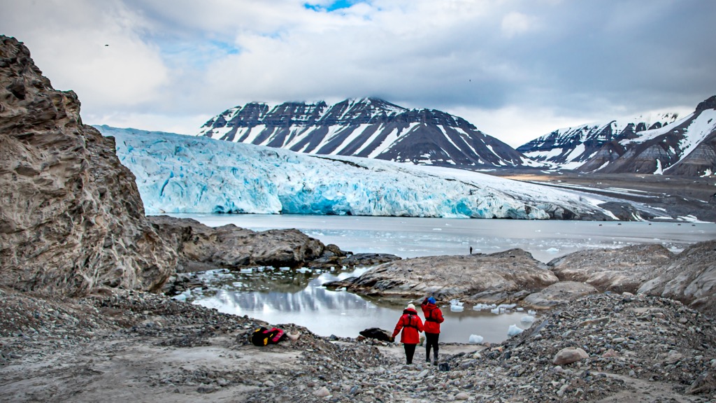 Hiking near giant blue glacier, Svalbard, Norway