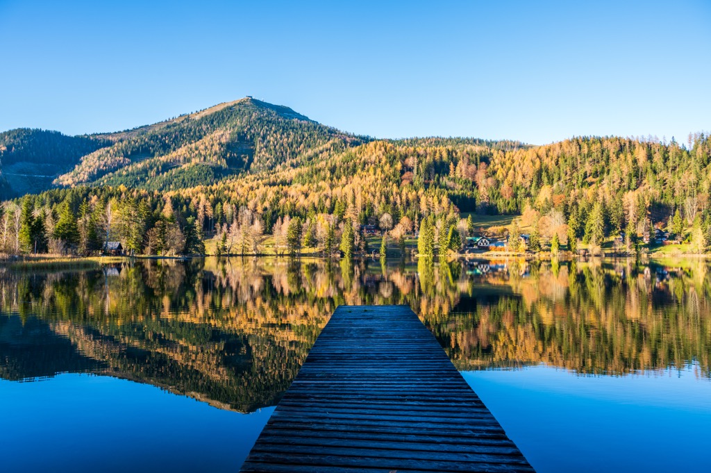 Herbstwald spiegelt sich im Erlaufsee bei Mariazell, Steiermark