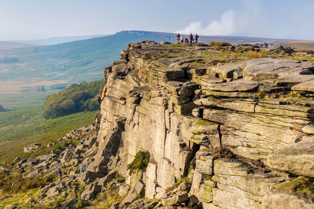 Stanage Edge in Peak District with hikers in bacground, England, UK
