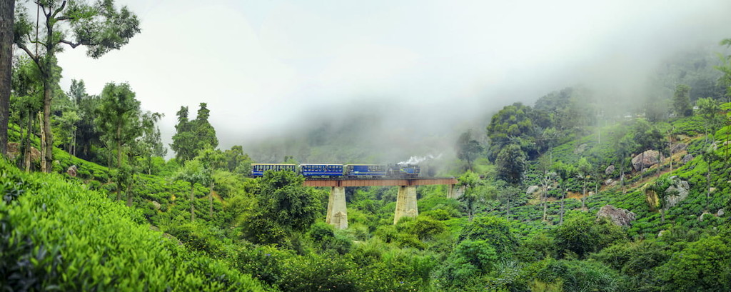 The toy train in Ooty, Tamil Nadu india running in the bridge between misty mountains in winter season. Tamil Nadu, India